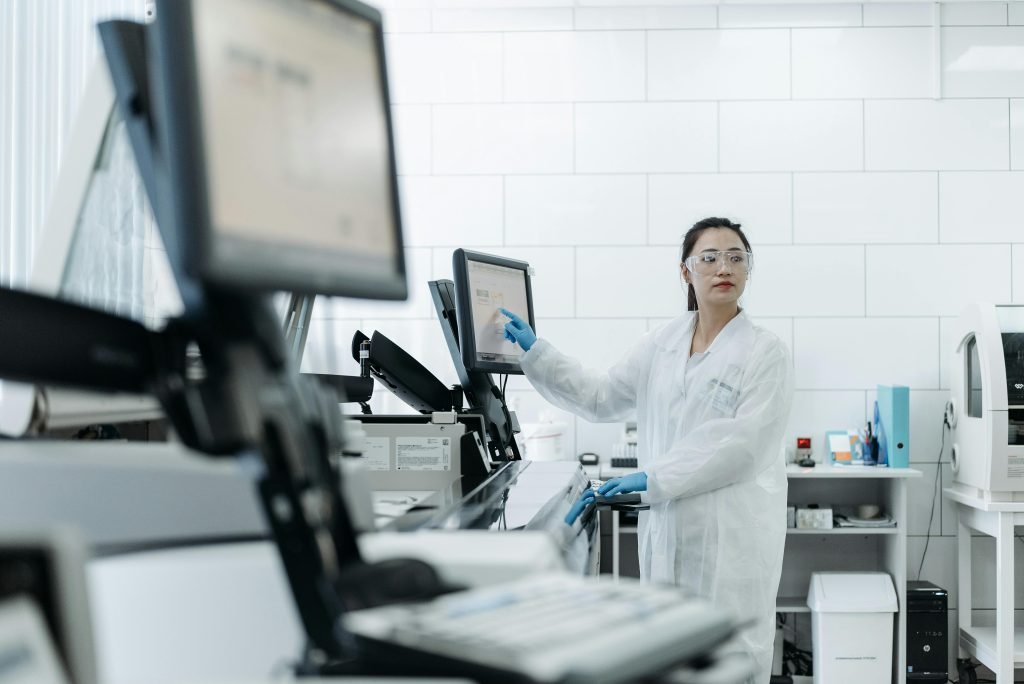 Lab technician in a white coat using medical equipment in a modern laboratory setting.